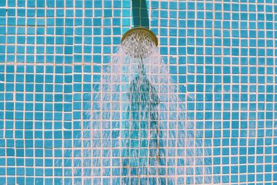 Close-up of water running from shower head in bathroom