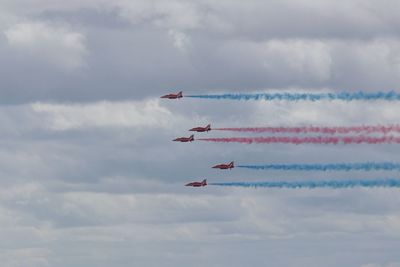 Low angle view of airshow against sky