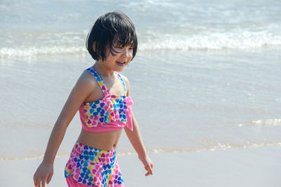 Girl wearing swimwear standing at beach