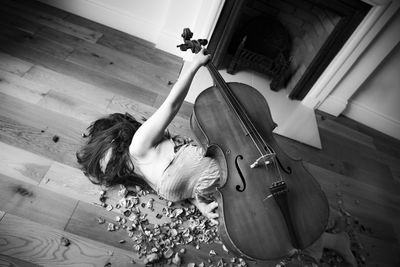 High angle view of woman playing guitar at home