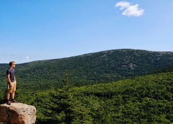 Woman standing on mountain against sky