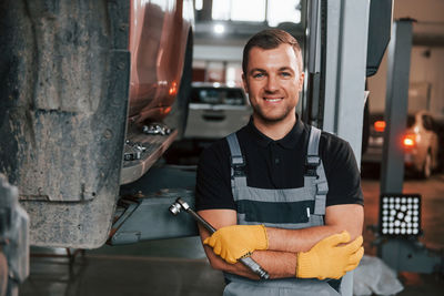 Man in uniform is in the auto service.