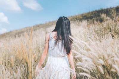 Woman standing on field against sky