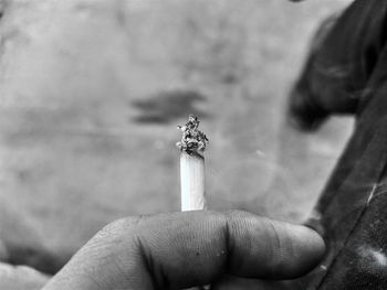 Midsection of person holding cigarette