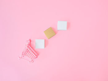 High angle view of paper toy against pink background