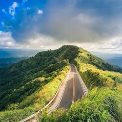 Panoramic view of road leading towards mountains against sky