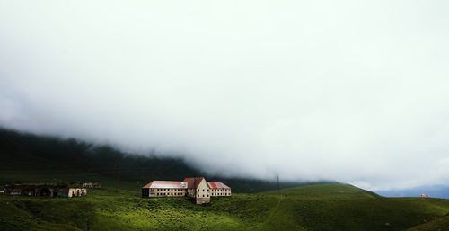 Houses on field against sky