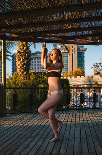 Full length of woman looking away while exercising outdoors