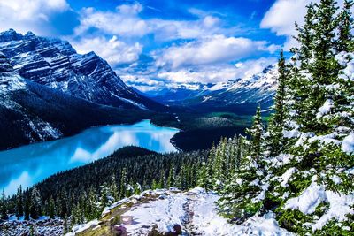 Scenic view of snow covered mountains against blue sky