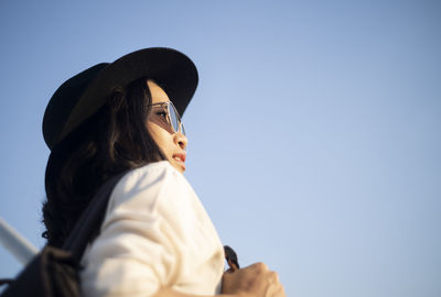 Portrait of woman wearing hat against sky