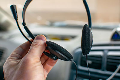 View of stereo headphones with soft foam pads with a microphone in the hand of a person, a driver