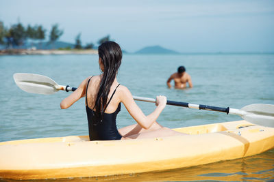 Rear view of woman swimming in sea