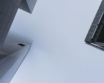 Directly below shot of modern buildings against clear sky