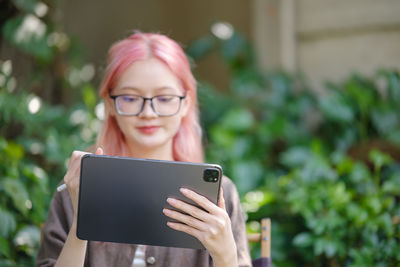 Portrait of young woman using digital tablet