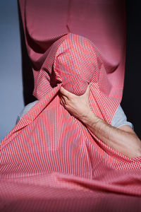 Close-up of man covering face with curtain