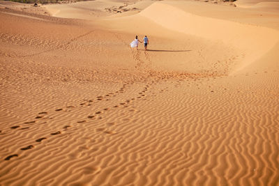 People walking on sand at beach