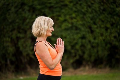 Side view of woman standing against blurred background