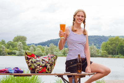 Portrait of young woman holding beer