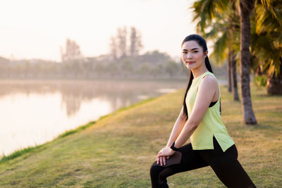 Full length portrait of woman against lake