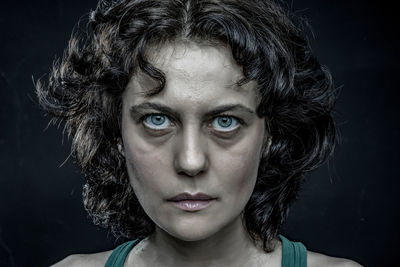 Close-up portrait of a beautiful young woman over black background