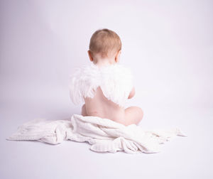 Side view of shirtless man standing against white background