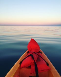 Life jackets on boat in sea against clear sky during sunset