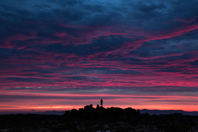 Silhouette landscape against sky at sunset