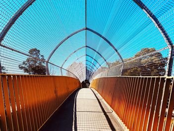 View of footbridge in city against sky