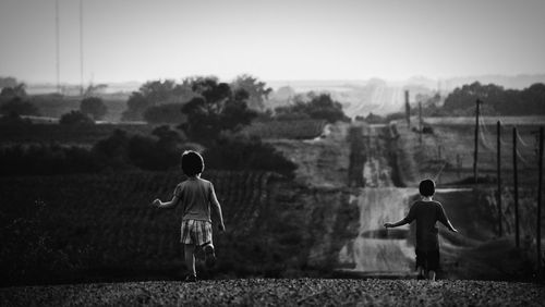 Full length rear view of boy standing on field