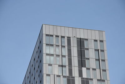 Low angle view of modern building against clear blue sky
