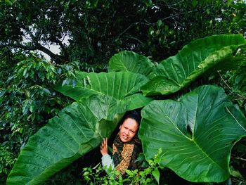 Portrait of a smiling young woman in huge plant