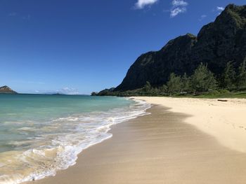 Scenic view of beach against blue sky