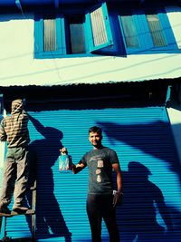 Full length of man standing against built structure