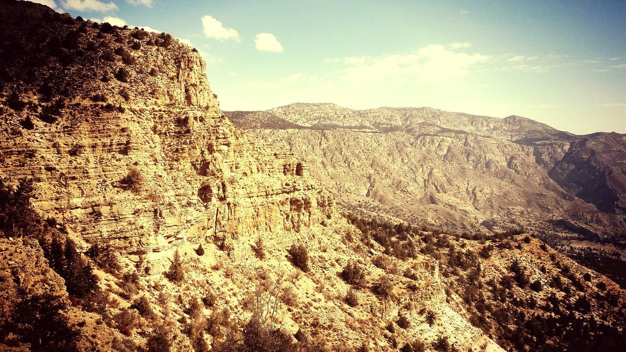 mountain, sky, rock formation, tranquility, tranquil scene, physical geography, scenics, geology, nature, low angle view, rock - object, beauty in nature, landscape, rocky mountains, mountain range, cloud - sky, arid climate, famous place, non-urban scene, desert