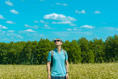 Portrait of young woman standing against sky