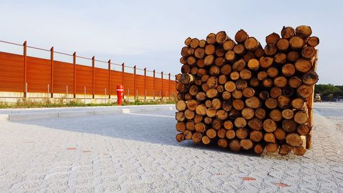 Stack of logs against sky