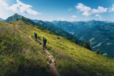 People walking on mountain against sky