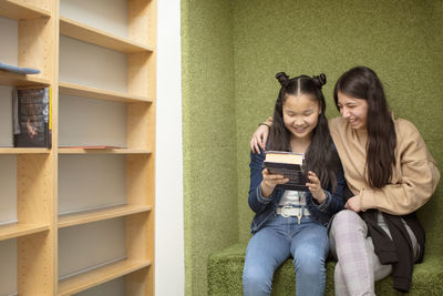 Smiling teenage girls sitting together