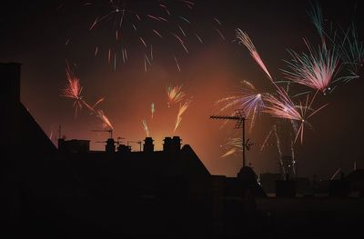 Low angle view of silhouette building against firework display