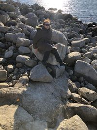 Man sitting on rock at beach