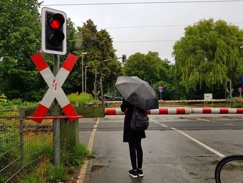 Full length of woman walking at railroad crossing