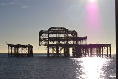 Abandoned palace pier in sea against sky