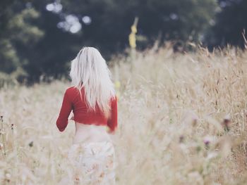 Rear view of woman standing in field