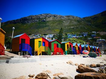 Multi colored houses on beach against clear blue sky