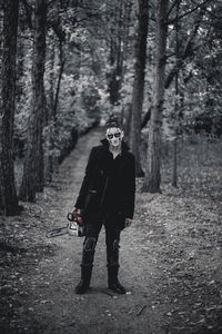 Full length portrait of man standing in forest