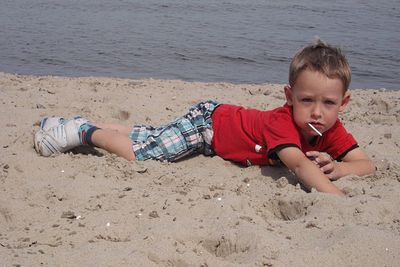 Portrait of boy lying down at beach