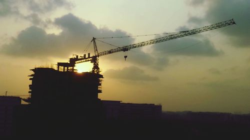Low angle view of cranes at construction site