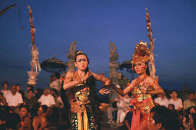 Group of people in traditional clothing against sky