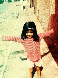 Portrait of girl standing against wall