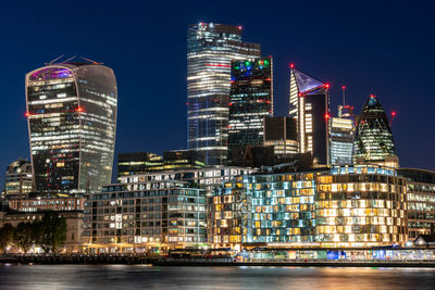 Illuminated buildings against sky at night